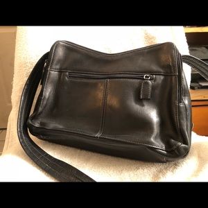 A black leather Tignanello bag. strap attached.